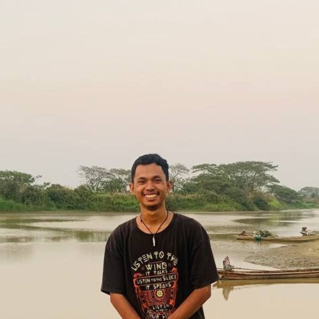 smiling guy standing at the side of river